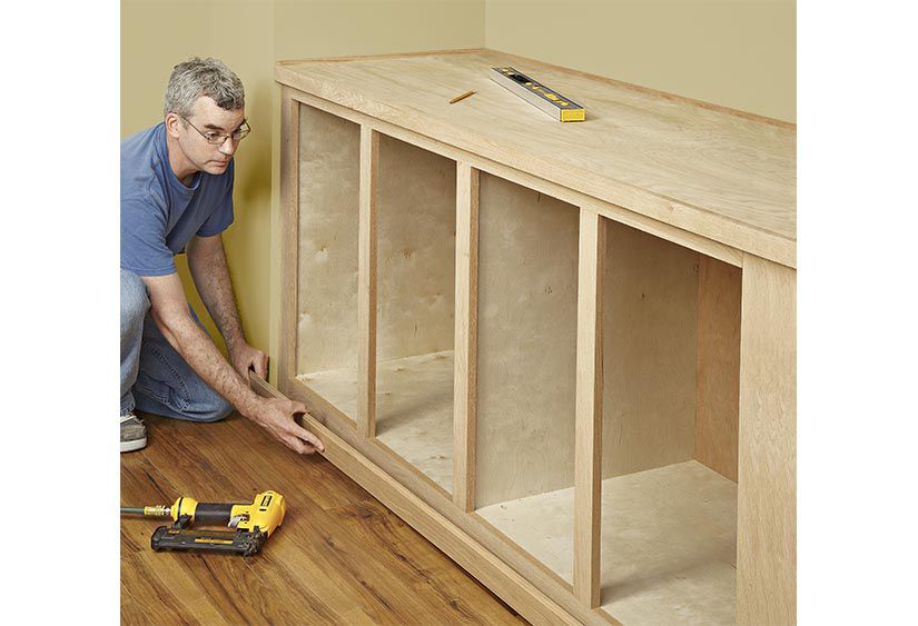 Dublin carpenter installing custom-built shelving unit in living room