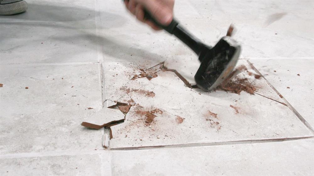 Professional tiler repairing cracked floor tiles in Dublin