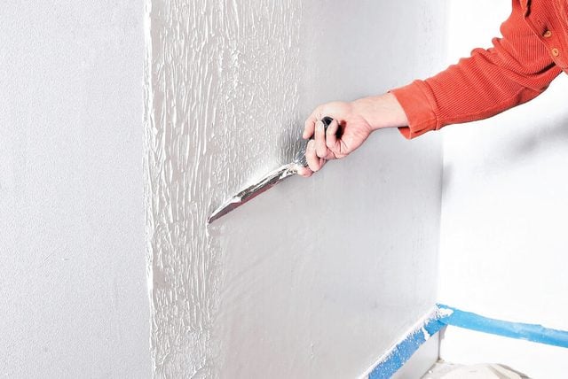 Plasterer skimming a wall for smooth wall finishing in Dublin