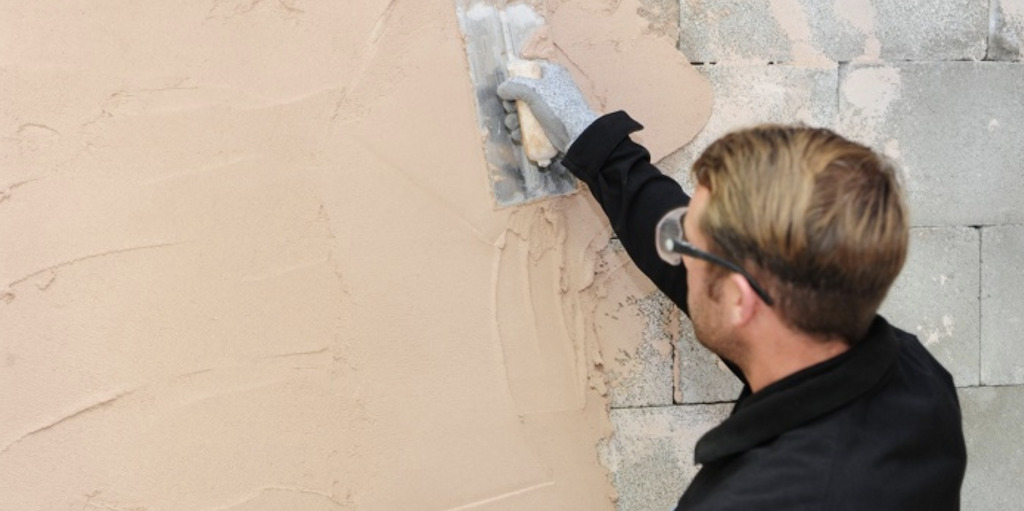 Plasterer applying plaster to a wall in a Dublin home