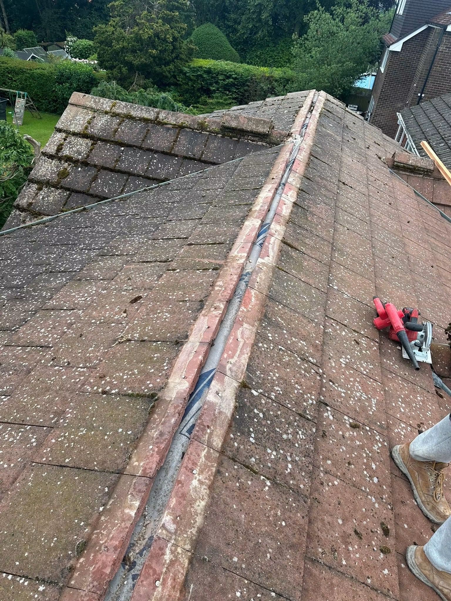 Hip with the ridge tiles lifted and the old mortar being cleaned off