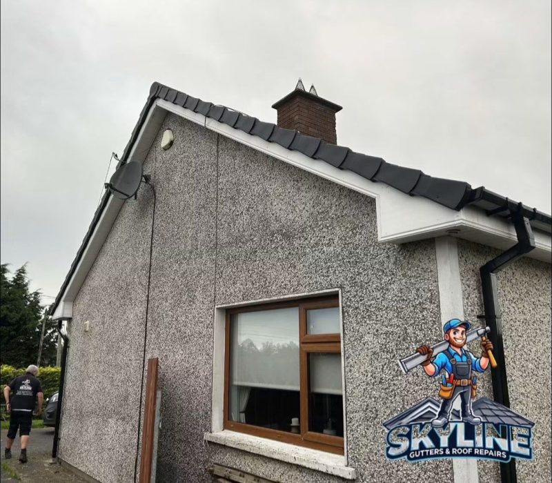 The same gable with black dry verge caps and a new downpipe